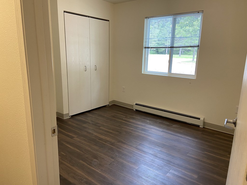 an empty room with wood floors and a window